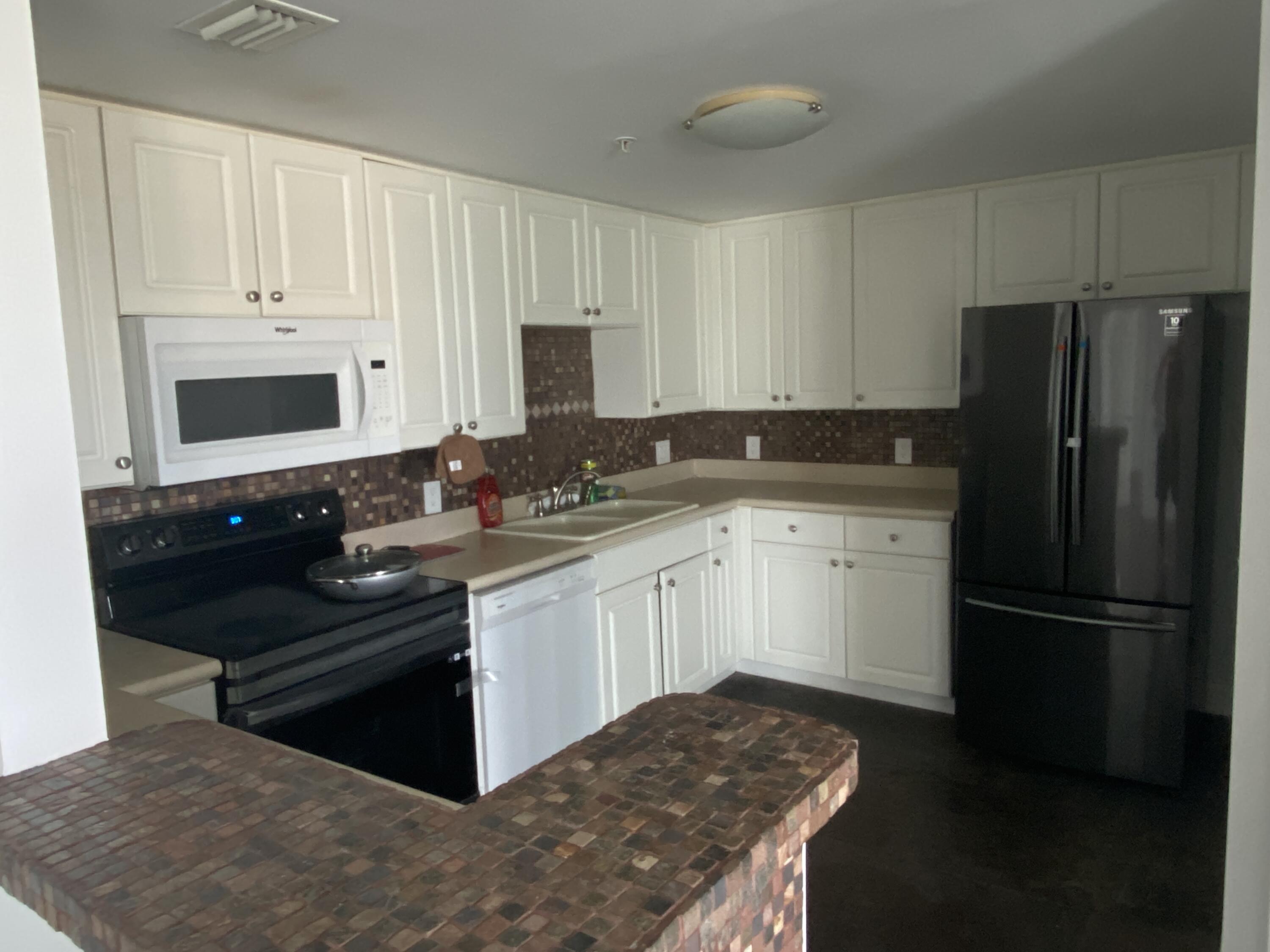 1627 Southwest 37th Avenue, Unit 1003 Miami, FL 33145 - Photo 2 of 12 a kitchen with a sink stove and refrigerator