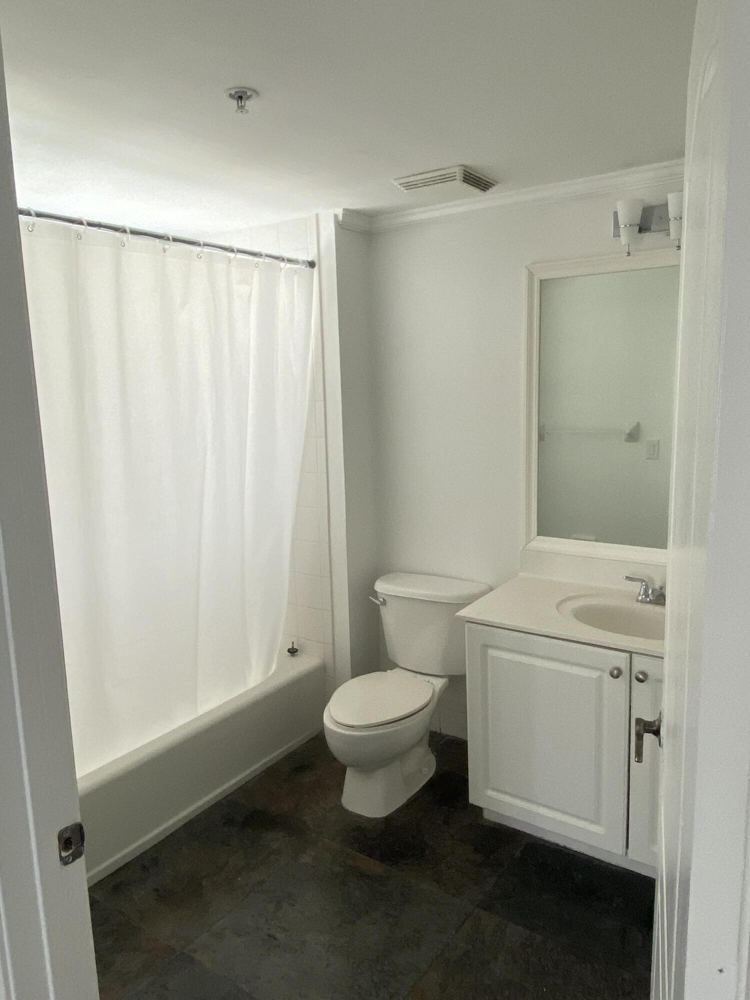 1627 Southwest 37th Avenue, Unit 1003 Miami, FL 33145 - Photo 8 of 12 a white toilet sitting next to a bathroom sink