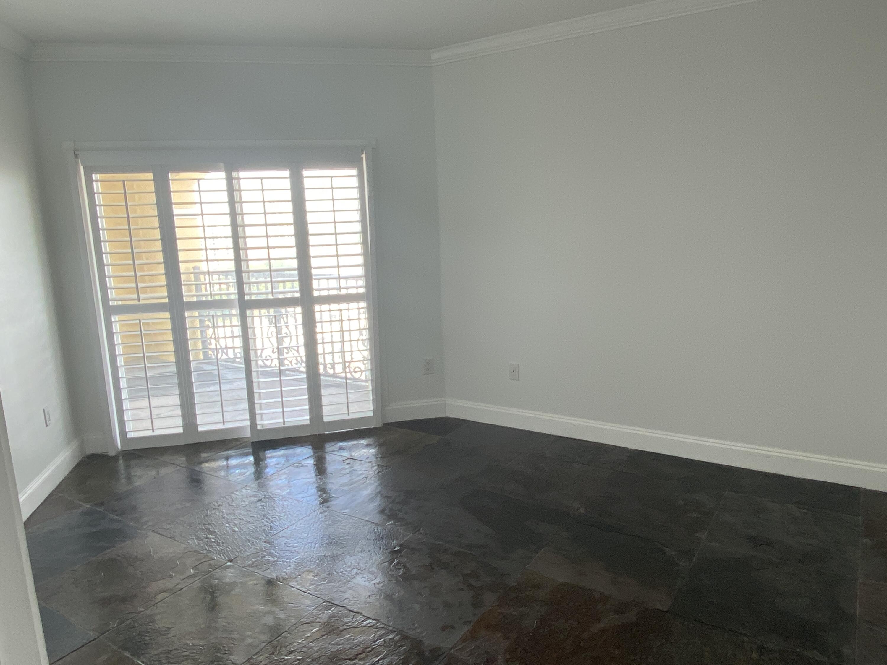 1627 Southwest 37th Avenue, Unit 1003 Miami, FL 33145 - Photo 9 of 12 a view of an empty room with wooden floor and a window