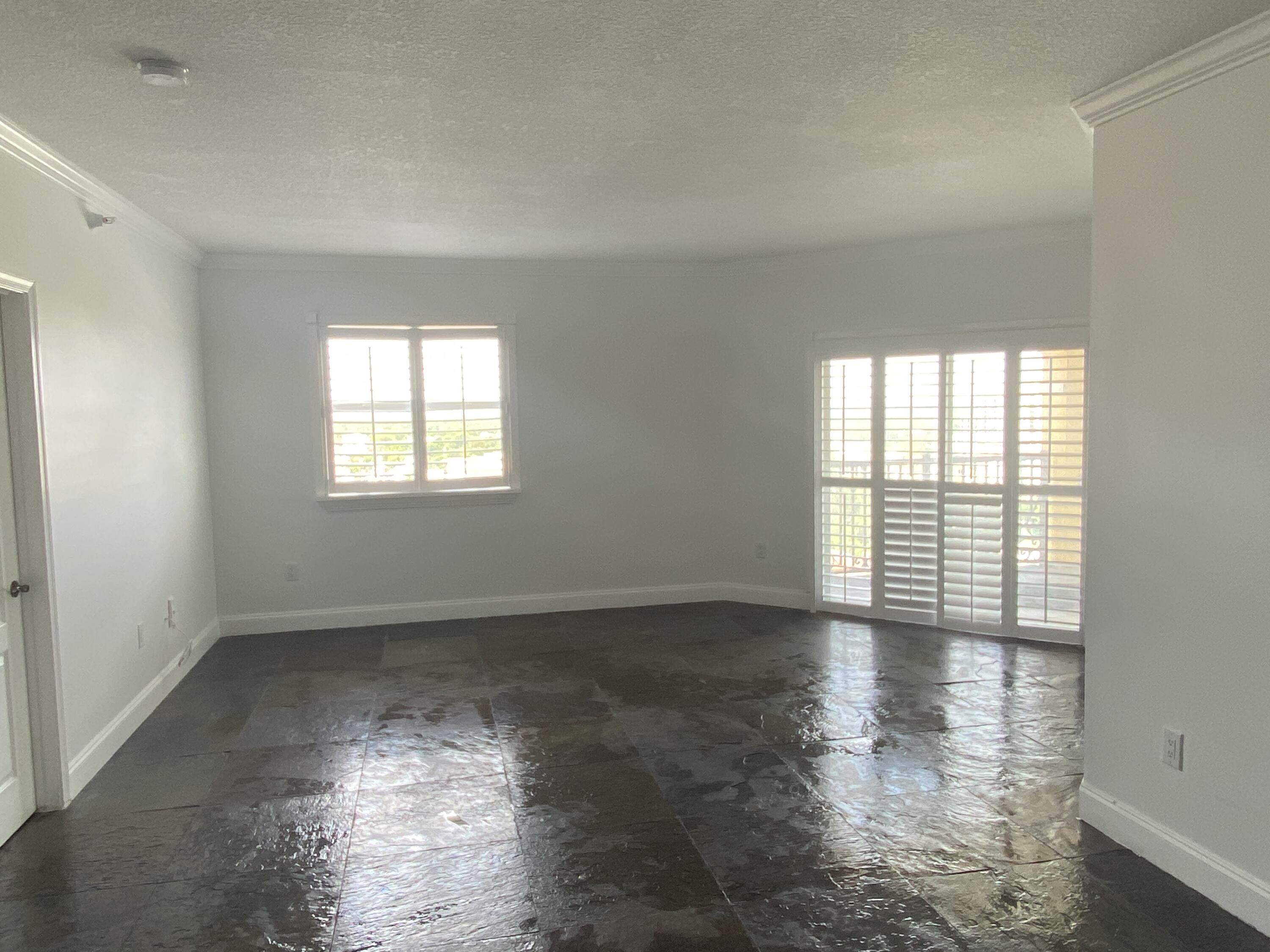1627 Southwest 37th Avenue, Unit 1003 Miami, FL 33145 - Photo 10 of 12 a view of an empty room with wooden floor and a window