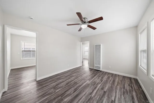a kitchen with granite countertop wooden floors stainless steel appliances and white cabinets