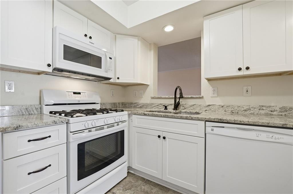 3301 Henderson Mill Road, Unit J1 Atlanta, GA 30341 - Photo 11 of 38 a kitchen with granite countertop white cabinets and white appliances