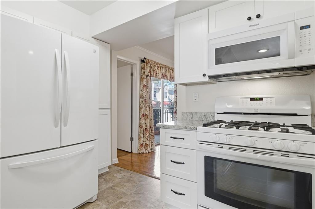 3301 Henderson Mill Road, Unit J1 Atlanta, GA 30341 - Photo 13 of 38 a kitchen with stainless steel appliances white cabinets and stove top oven