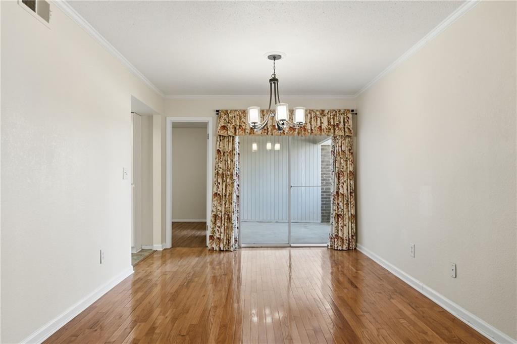3301 Henderson Mill Road, Unit J1 Atlanta, GA 30341 - Photo 9 of 38 an empty room with wooden floor and chandelier