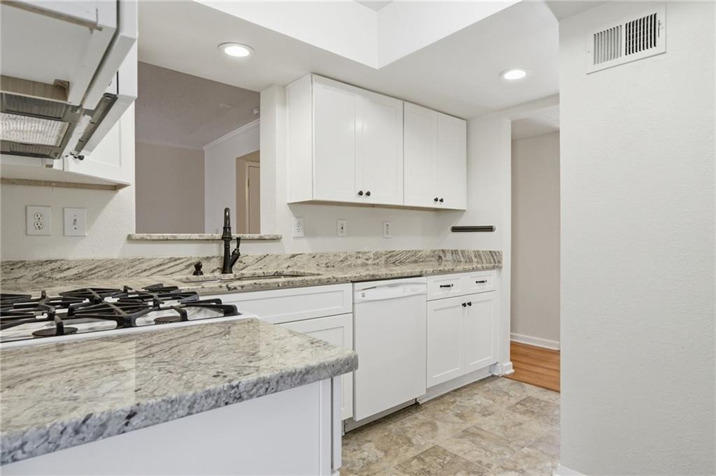 3301 Henderson Mill Road, Unit J1 Atlanta, GA 30341 - Photo 10 of 38 a kitchen with granite countertop white cabinets and a stove