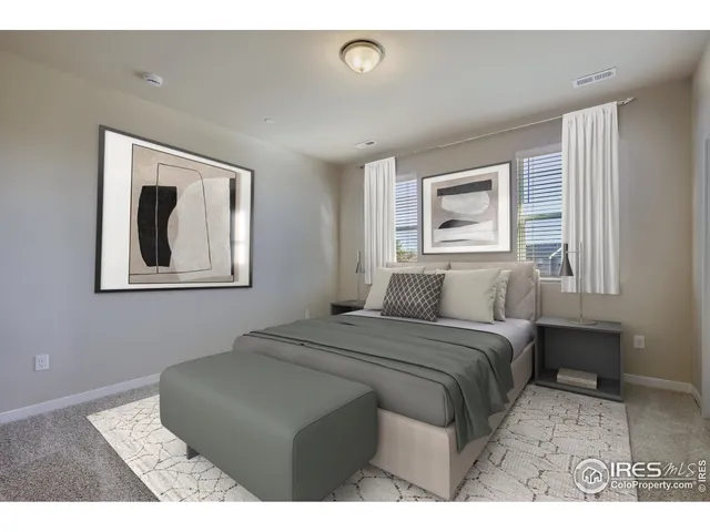 a bedroom with a bed and a painting on the wall