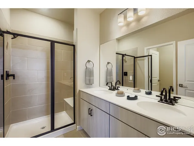 a bathroom with a double vanity sink mirror and shower