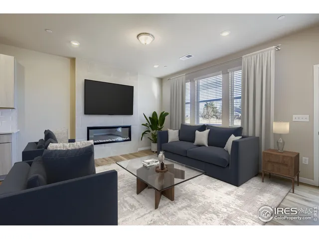a living room with furniture a flat screen tv and a window