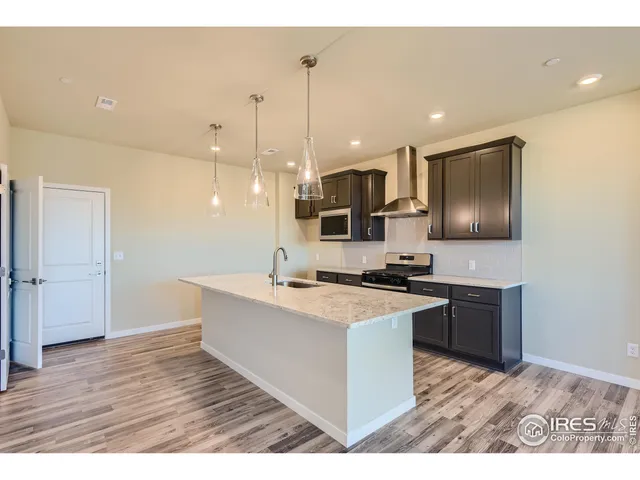 a kitchen with a sink a stove a refrigerator and a microwave