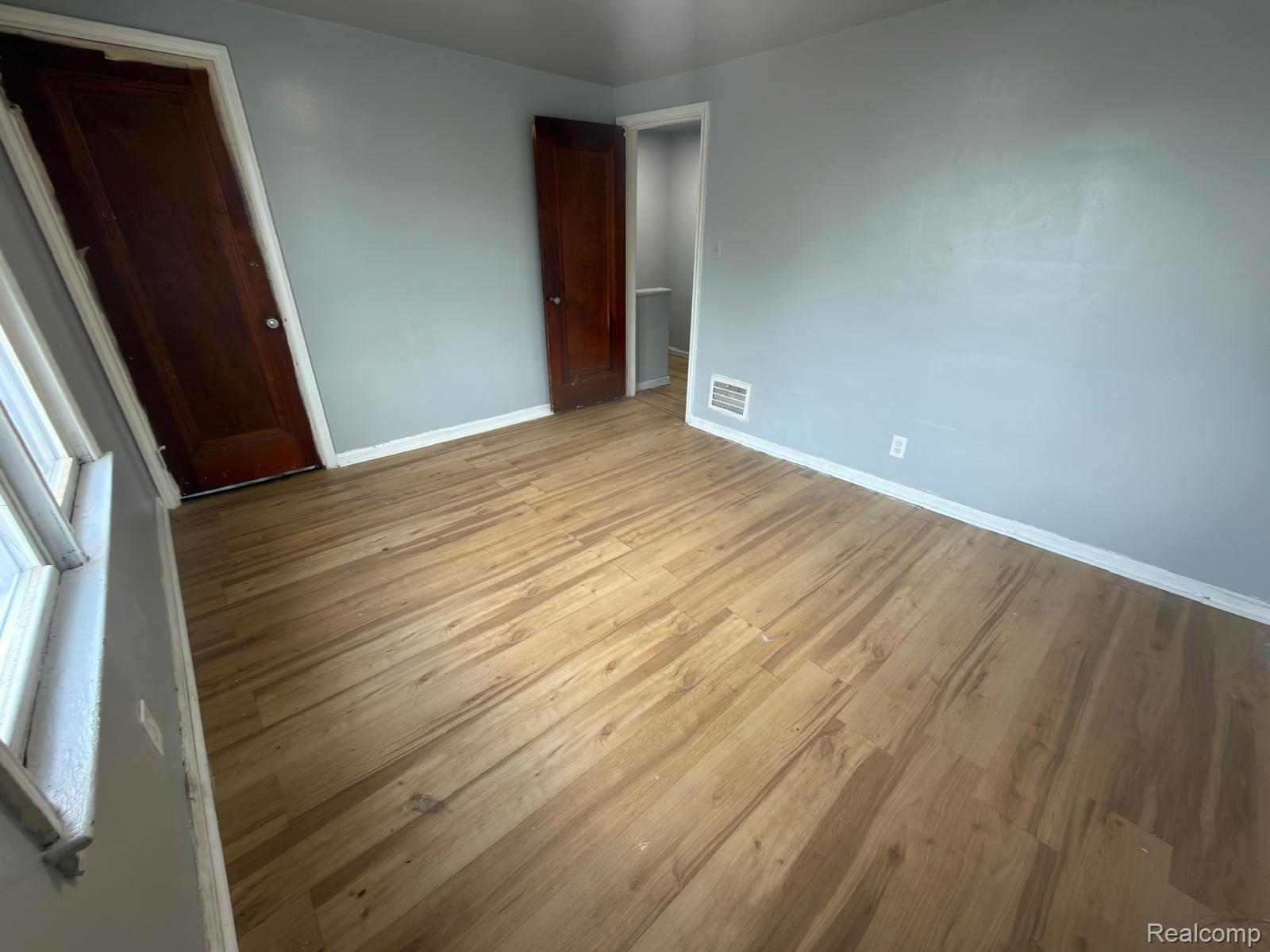 8837 Evergreen Road Detroit, MI 48228 - Photo 15 of 16 Spacious interior room featuring light-toned wood-finish flooring, light gray wall paint, and white trim