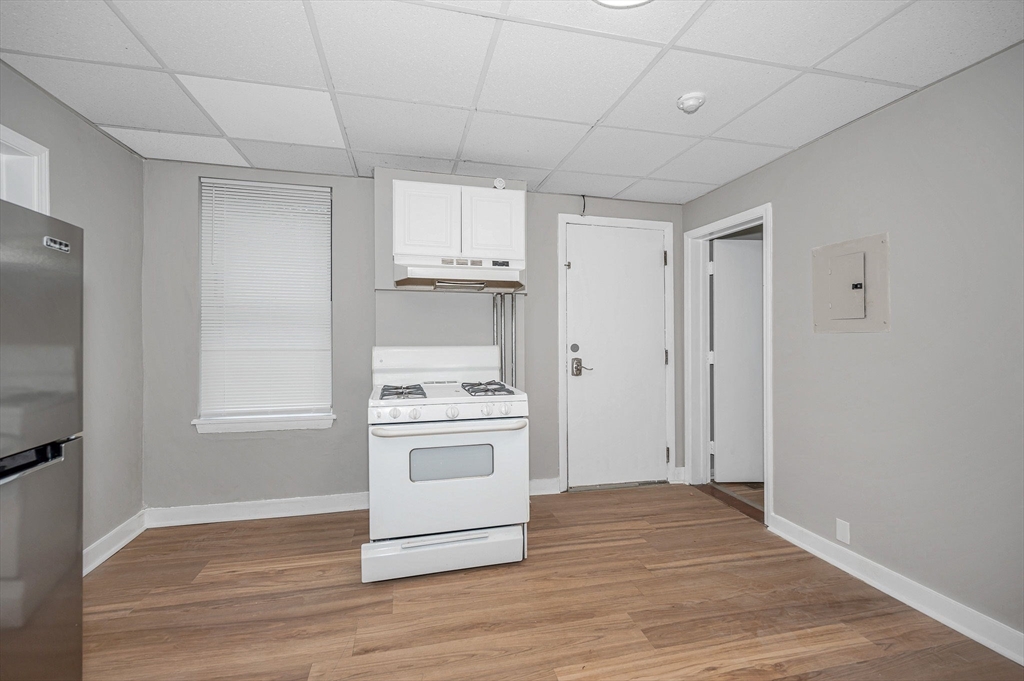 90 Appleton Street, Unit U:7 Lowell, MA 01852 - Photo 5 of 13 a kitchen with granite countertop a stove a sink and a refrigerator