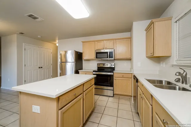 a kitchen with a sink a stove a refrigerator and cabinets