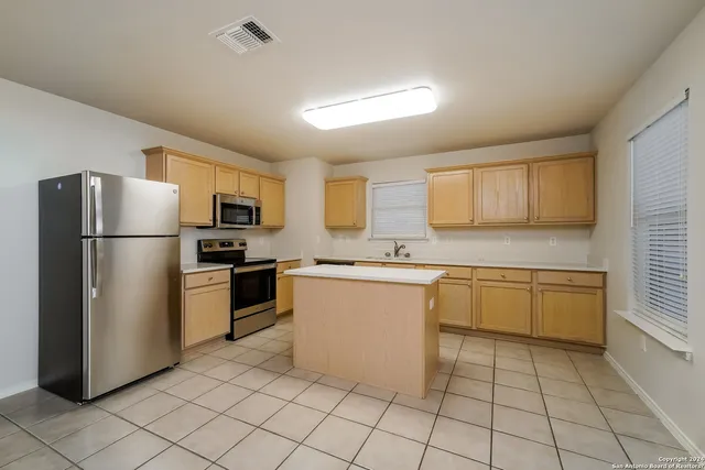 a kitchen with granite countertop a refrigerator and a sink