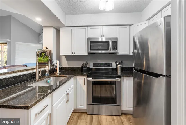 a kitchen with a refrigerator and a stove top oven