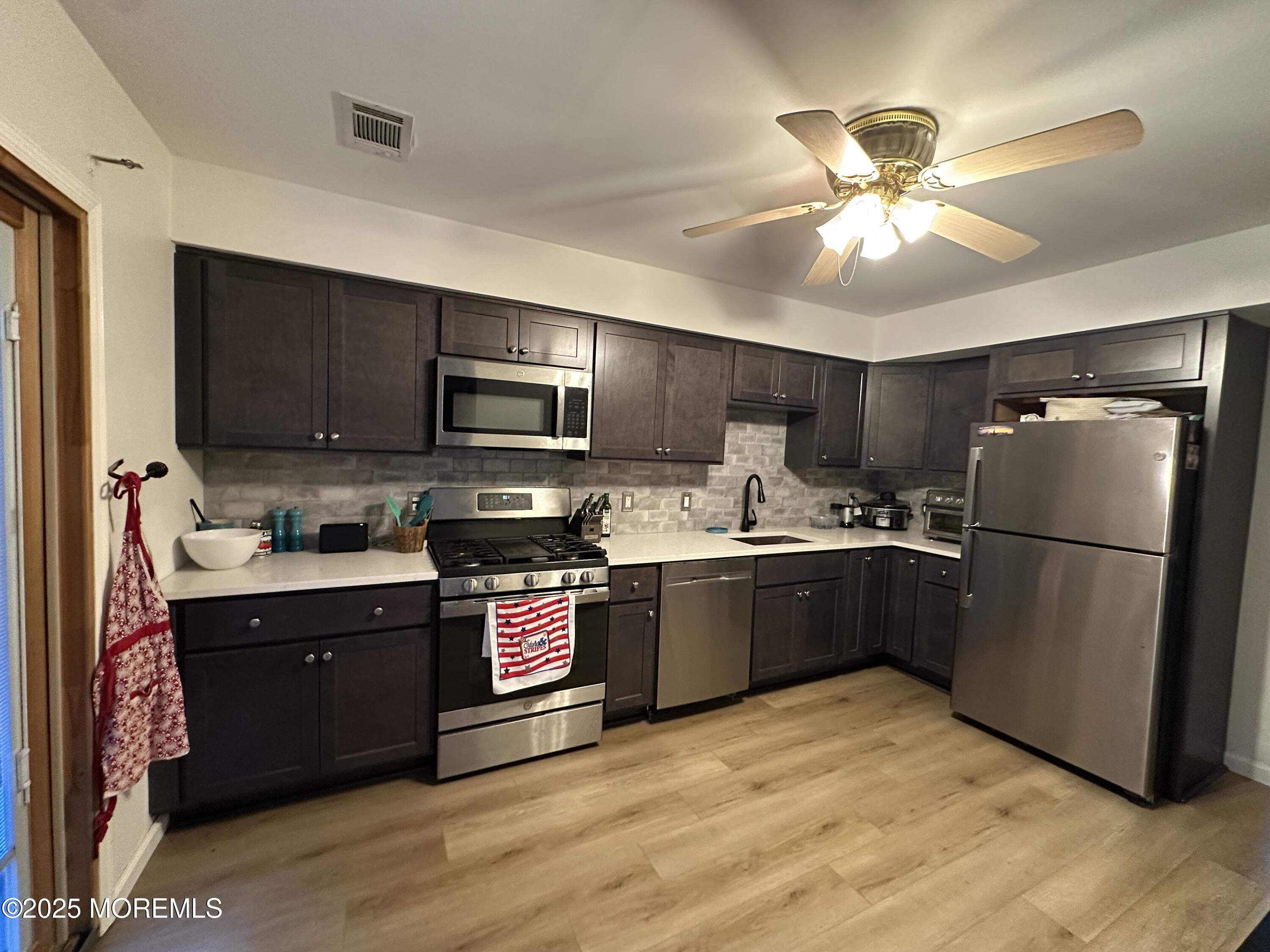 619 Sandra Place Brick, NJ 08724 - Photo 12 of 19 a kitchen with stainless steel appliances granite countertop a refrigerator a sink dishwasher a stove top oven a kitchen island and cabinetry