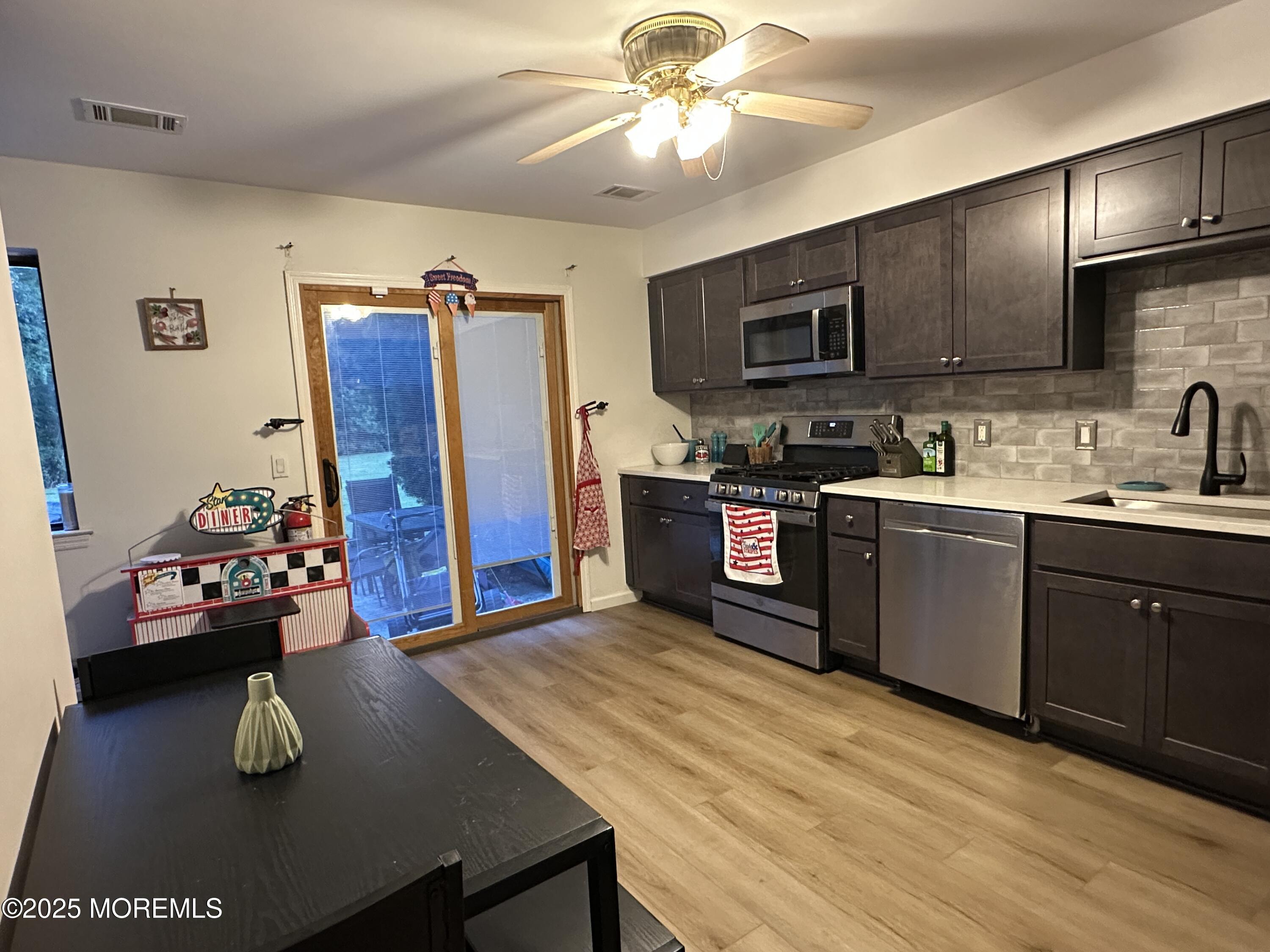 619 Sandra Place Brick, NJ 08724 - Photo 13 of 19 a kitchen with stainless steel appliances granite countertop a sink dishwasher stove and refrigerator with wooden floor