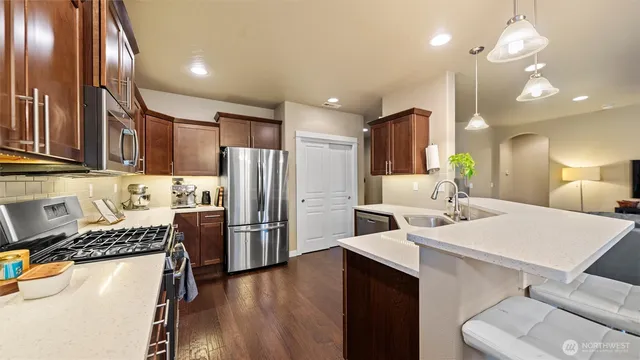 a kitchen with a sink a counter space appliances and cabinets