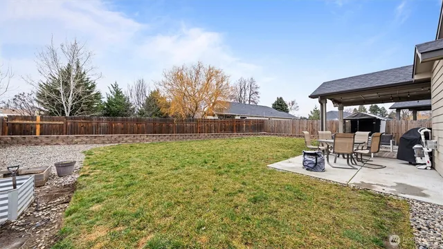 a view of a house with backyard and tree