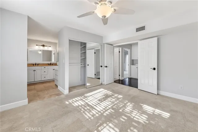 a view of a livingroom with a chandelier fan and kitchen view