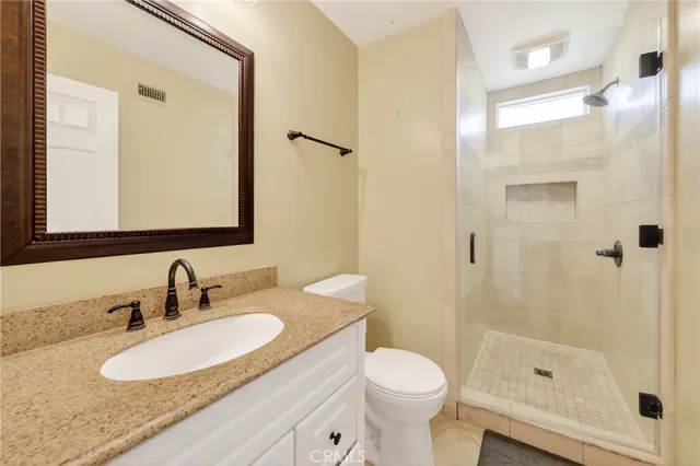 a bathroom with a granite countertop sink toilet and shower