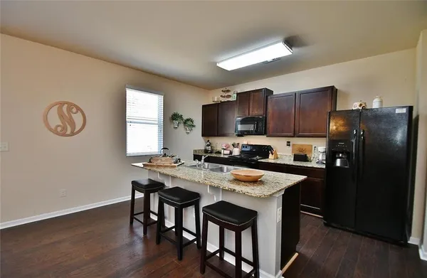 a kitchen with a table chairs refrigerator and microwave