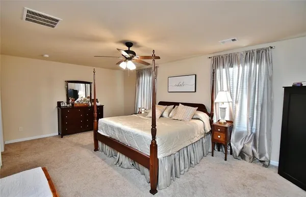 a spacious bedroom with a bed and a chandelier