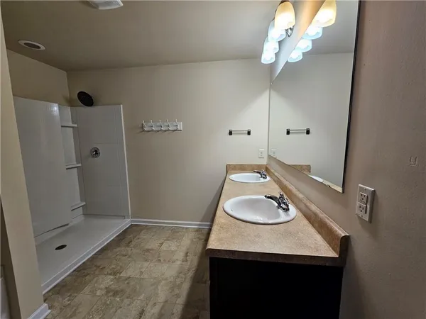 a bathroom with a sink and a mirror with shower