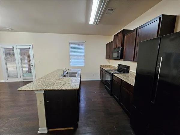 a kitchen with a sink a microwave a refrigerator and cabinets