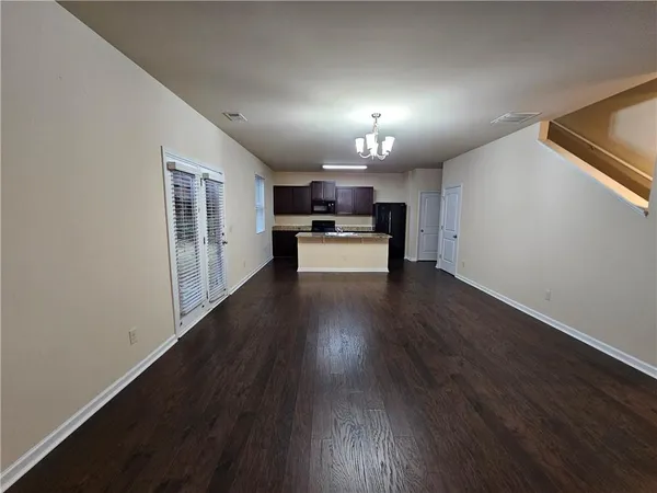 an empty room with wooden floor fireplace and windows