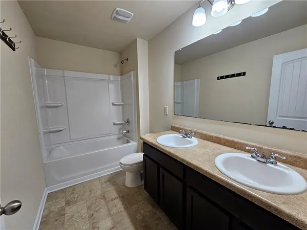 en empty room with windows and ceiling fan