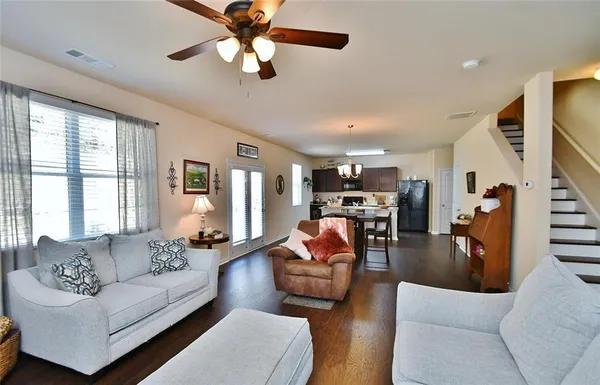 a living room with furniture kitchen view and a large window