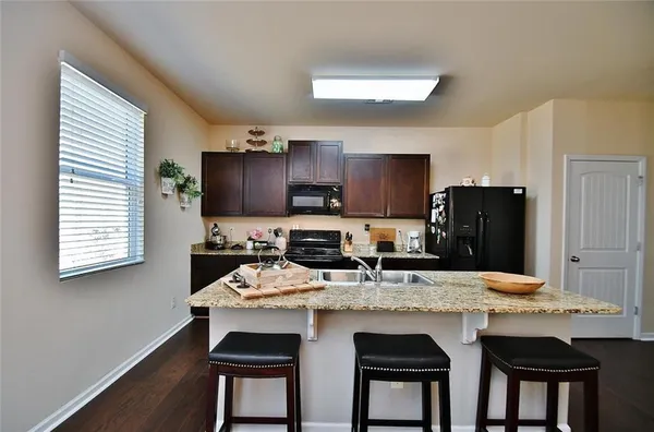 a kitchen with granite countertop kitchen island cabinets and refrigerator
