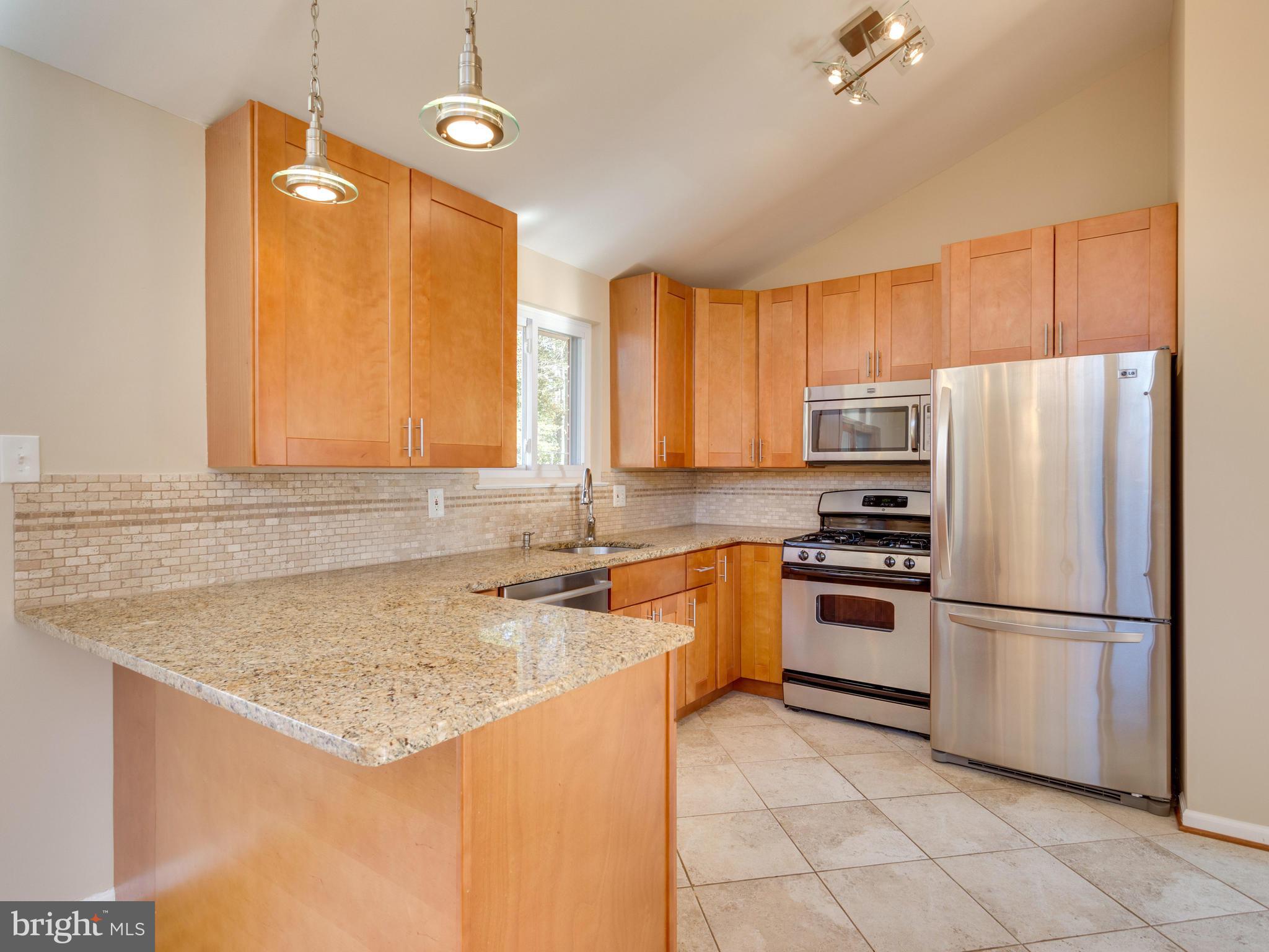 8702 Victoria Road Springfield, VA 22151 - Photo 8 of 27 a kitchen with a refrigerator a stove a sink and a refrigerator