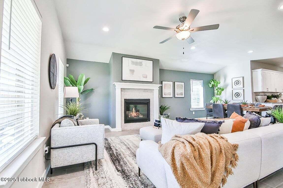 324 Ranger Street Wolfforth, TX 79382 - Photo 2 of 12 a living room with furniture a fireplace and a large window