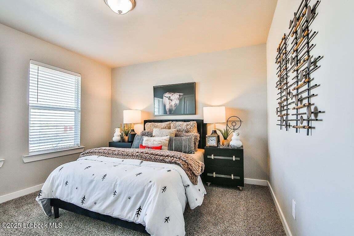 324 Ranger Street Wolfforth, TX 79382 - Photo 9 of 12 a bedroom with a bed and a chandelier