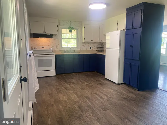 a front view of a house with a garden and trees