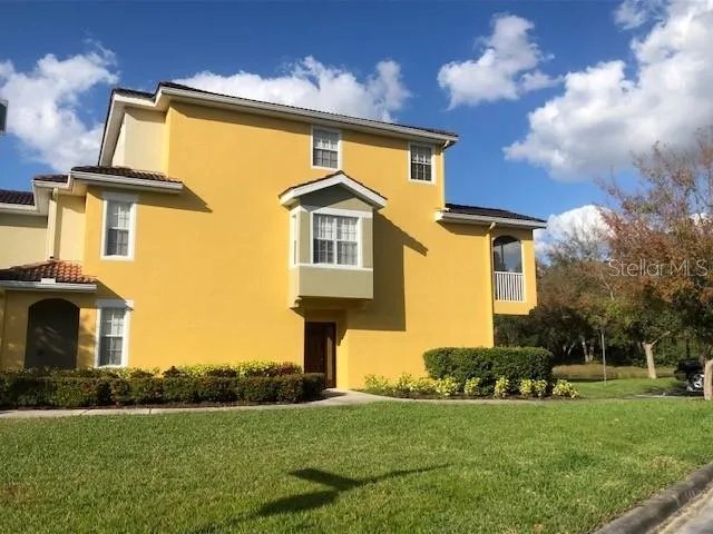a front view of a house with a yard and trees