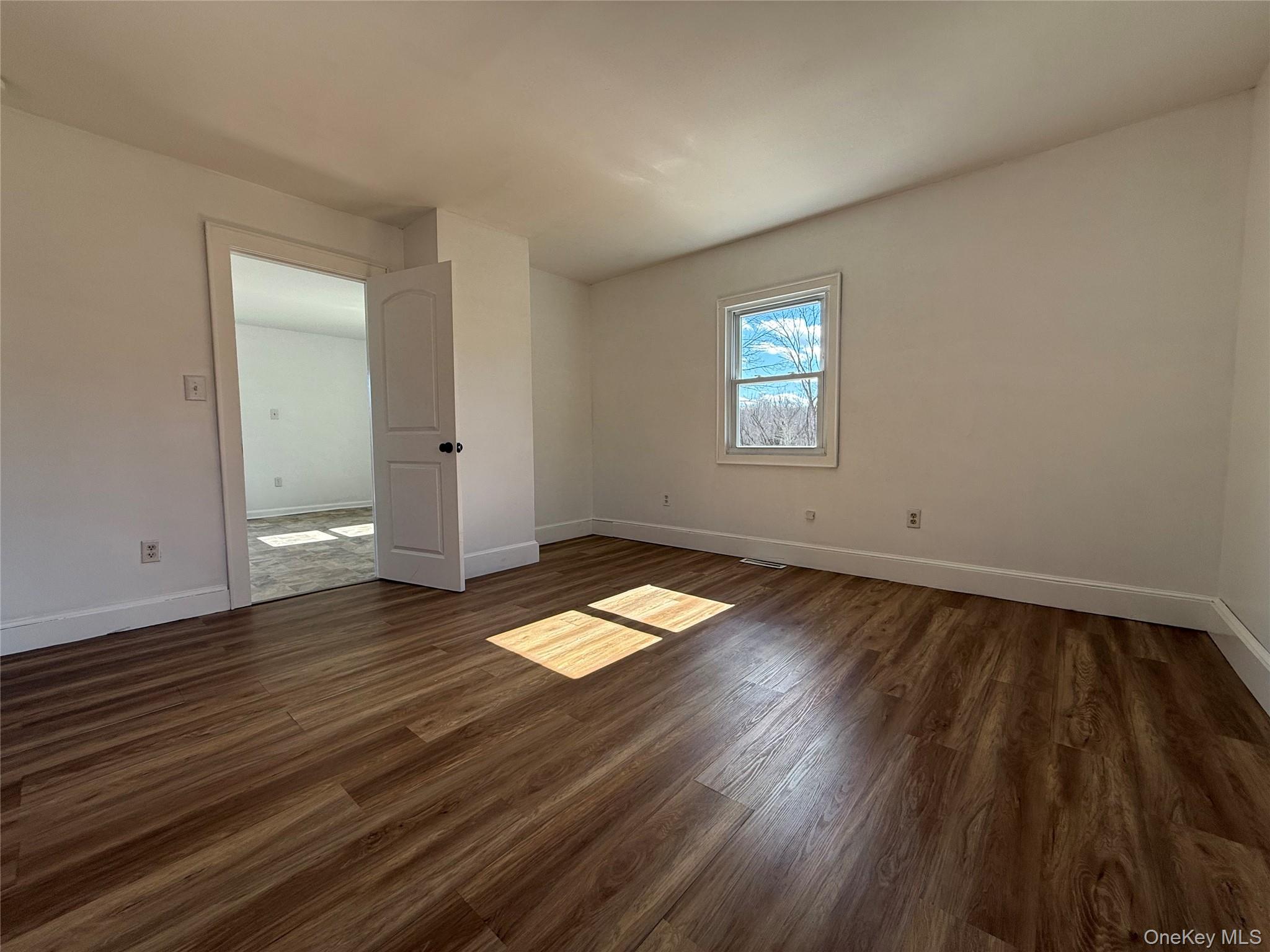 657 Eatontown Road Port Jervis, NY 12771 - Photo 6 of 14 an empty room with wooden floor and windows