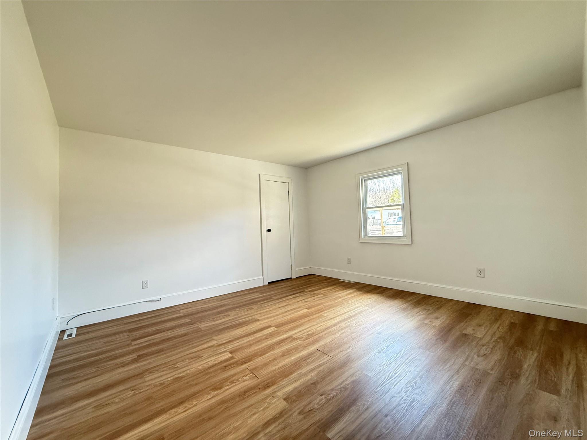 657 Eatontown Road Port Jervis, NY 12771 - Photo 8 of 14 an empty room with wooden floor and windows