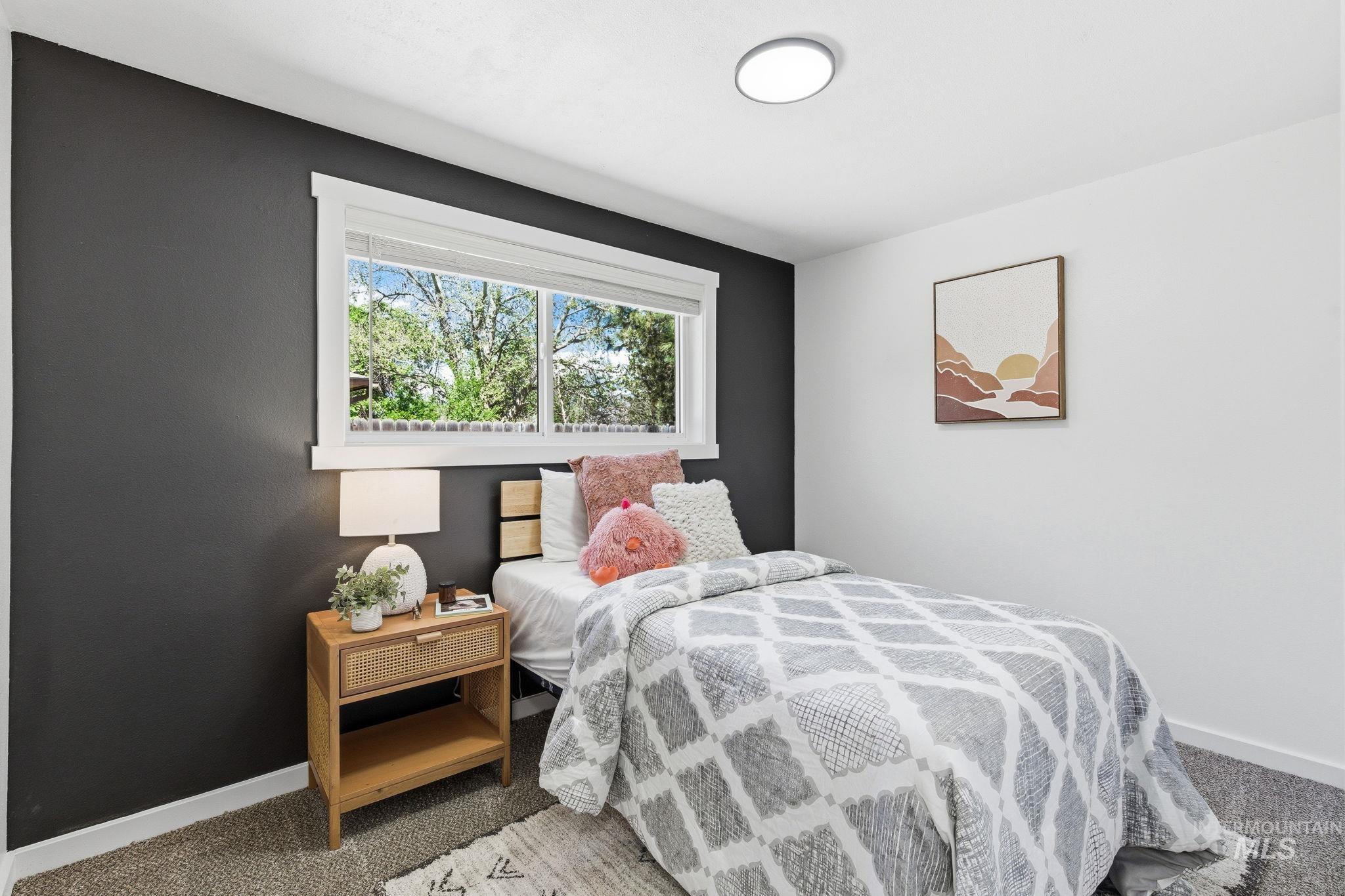 2224 Rachel Circle Boise, ID 83706 - Photo 28 of 50 Bedroom featuring a large window with white trim, dark accent wall, white walls, and a flush mount ceiling light