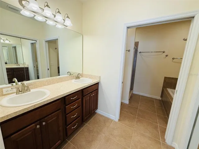 a bathroom with a double vanity sink a mirror and a shower