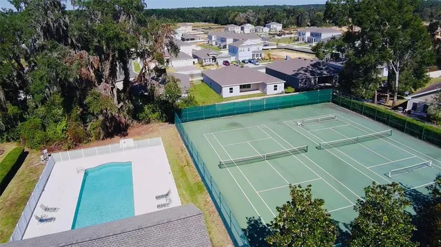 a view of a tennis ground with large trees