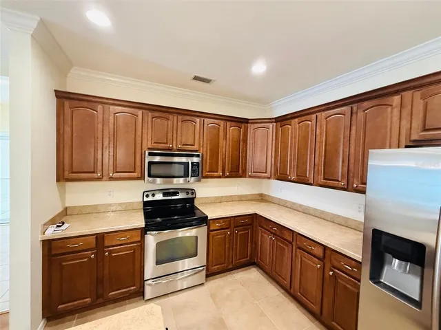 a kitchen with granite countertop wooden cabinets and stainless steel appliances