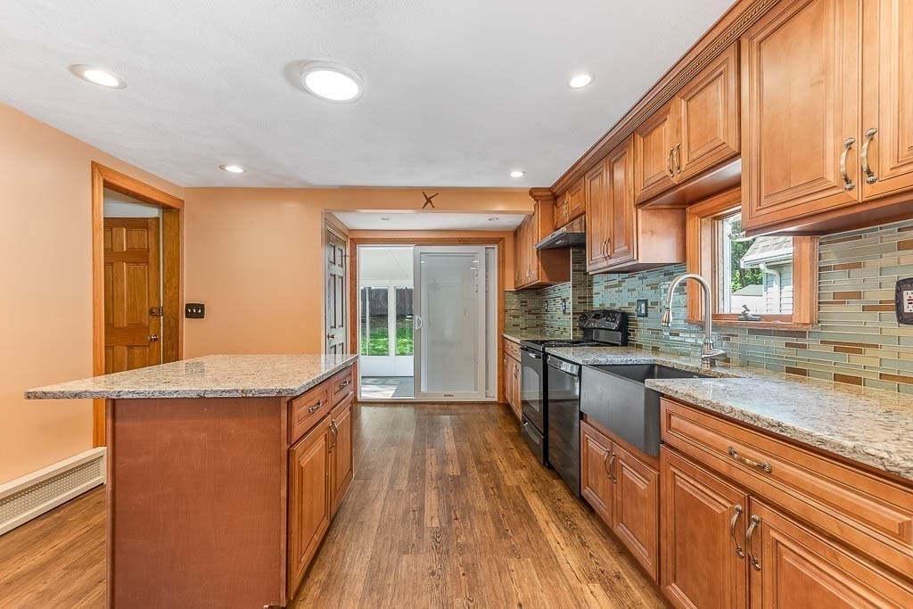 29 Berkeley Road Dedham, MA 02026 - Photo 11 of 35 a kitchen with granite countertop a sink a counter top space stainless steel appliances and cabinets