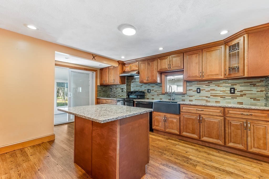 29 Berkeley Road Dedham, MA 02026 - Photo 12 of 35 a kitchen with stainless steel appliances granite countertop a stove a sink dishwasher and a refrigerator with wooden floor