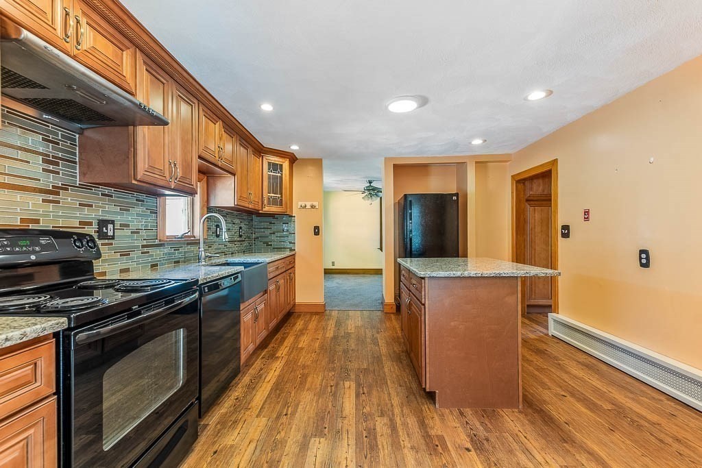 29 Berkeley Road Dedham, MA 02026 - Photo 13 of 35 a kitchen with stainless steel appliances kitchen island granite countertop a stove a sink and a refrigerator