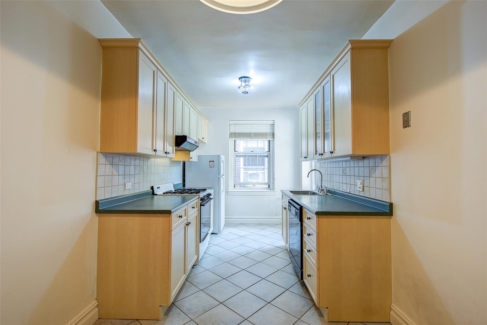 117-01 Park Lane South, Unit C5D Queens, NY 11418 - Photo 12 of 33 a kitchen with granite countertop a sink and a stove top oven