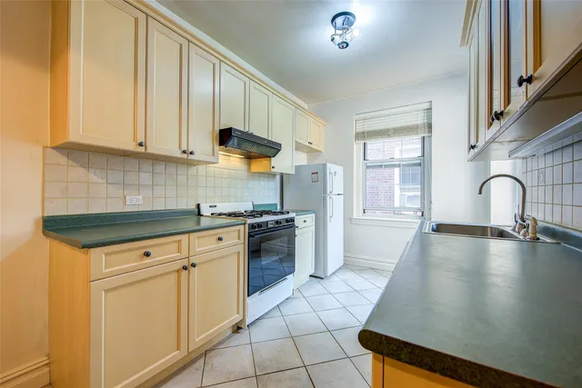 a kitchen with granite countertop a sink a stove and cabinets
