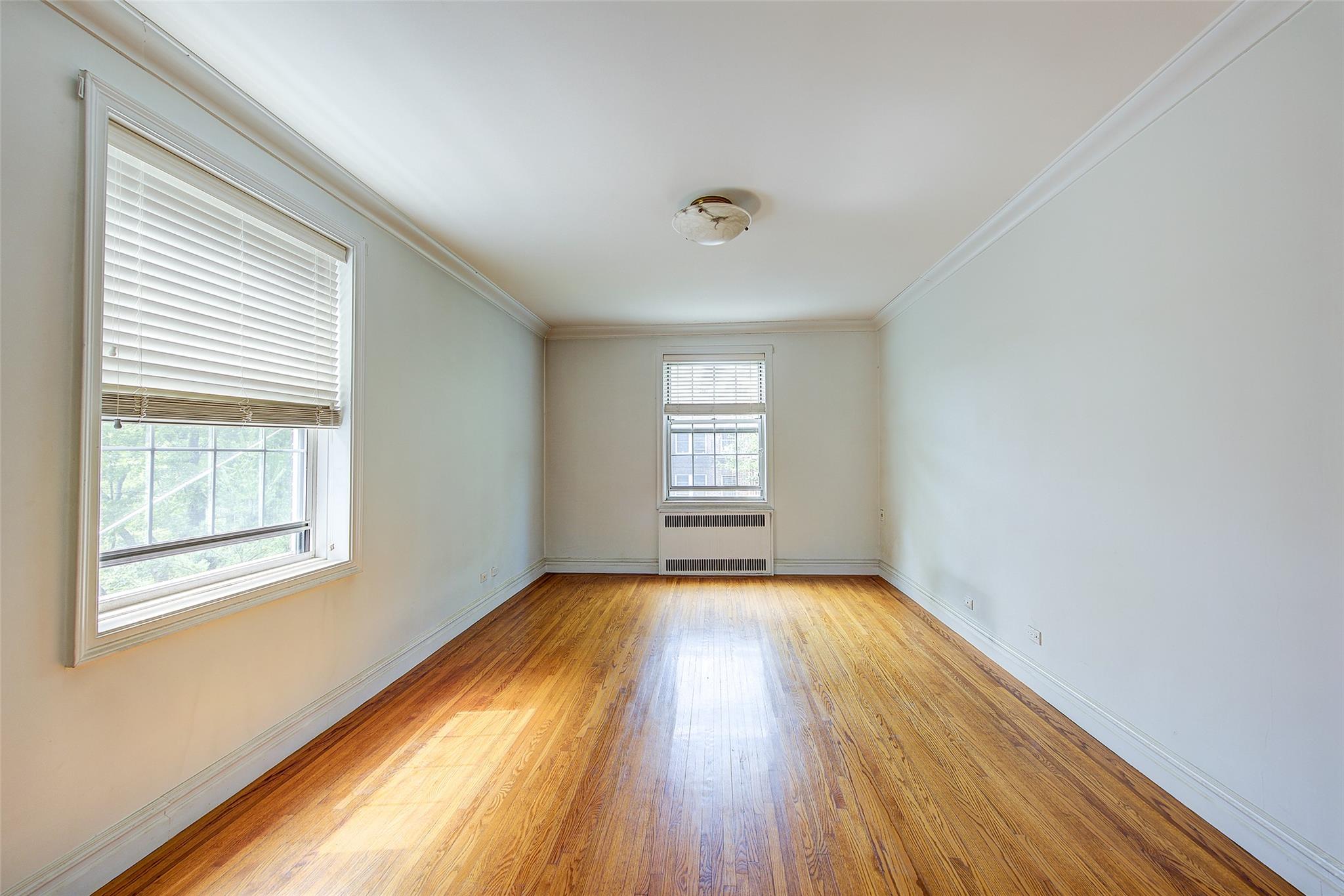 117-01 Park Lane South, Unit C5D Queens, NY 11418 - Photo 17 of 33 an empty room with wooden floor and windows