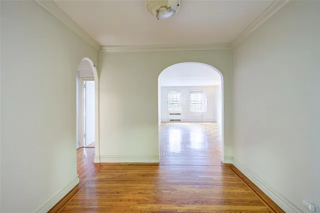 an empty room with wooden floor and a window